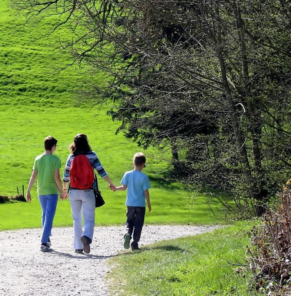 Familie läuft entlang eines Feldweges